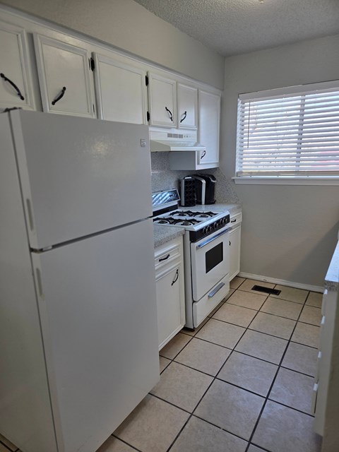 A white refrigerator and stove in a kitchen.