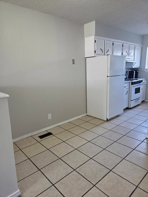 A kitchen with a white refrigerator and a white oven.