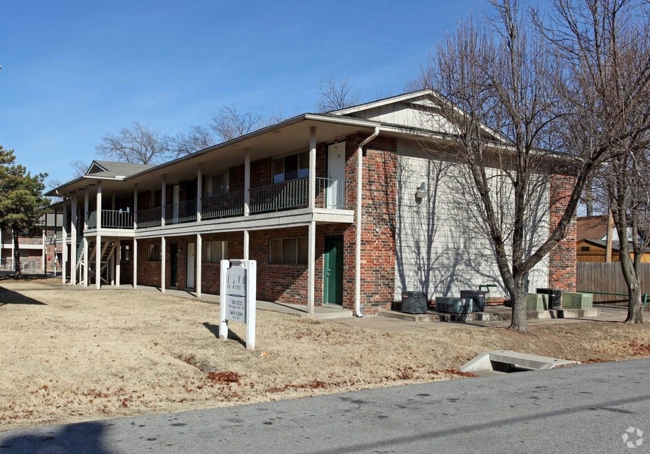 the front of an apartment building with a sign in front