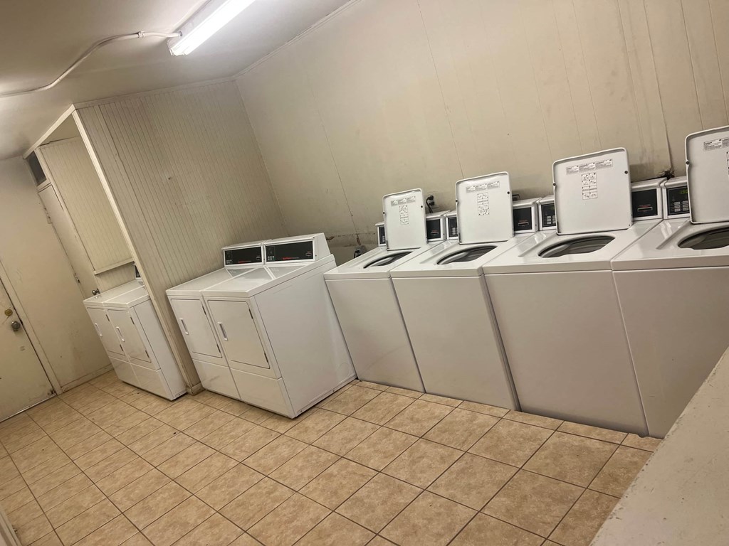 a row of washers and dryers in a laundry room