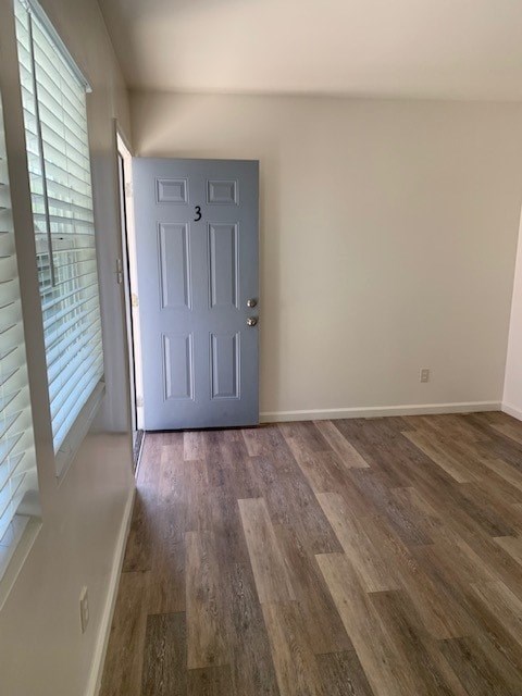 A room with a blue door and wooden flooring.