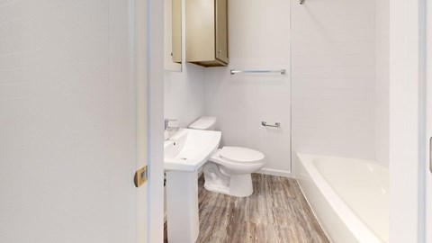 A white toilet and sink in a small bathroom.
