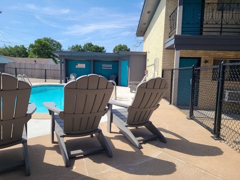 A poolside scene with chairs and a pool.