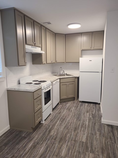A kitchen with a white fridge and a white stove top oven.