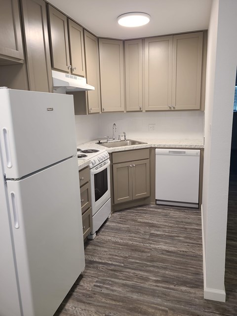A white refrigerator is in a kitchen with wooden cabinets.