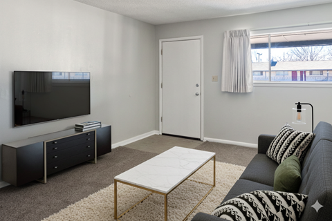 A living room with a grey couch and a white coffee table.