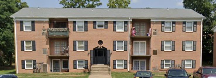 an apartment building with cars parked in front of it