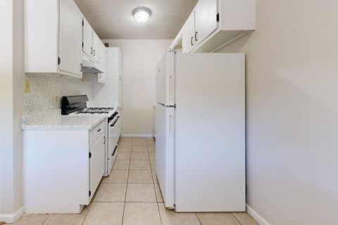 A kitchen with white appliances and cabinets.