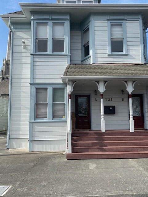 A two story house with a red front door and white columns.
