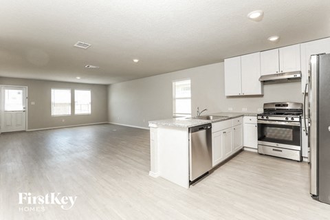 A kitchen with white appliances and wooden floors.