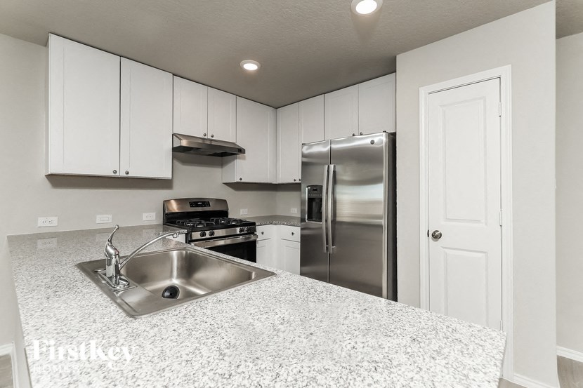 A kitchen with a granite countertop and stainless steel appliances.