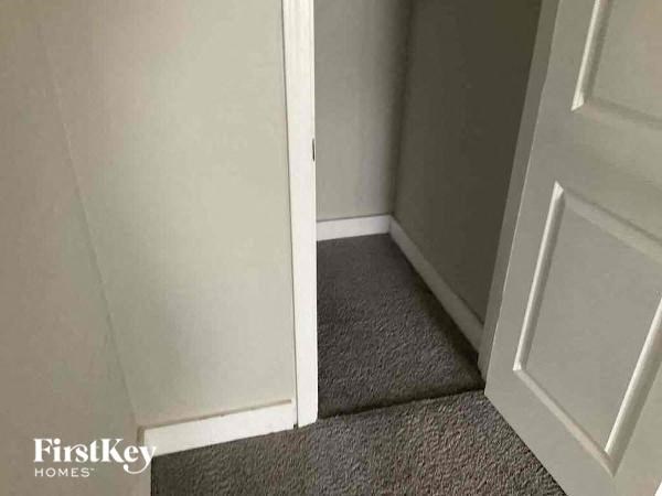 a hallway with an open door and a carpeted floor