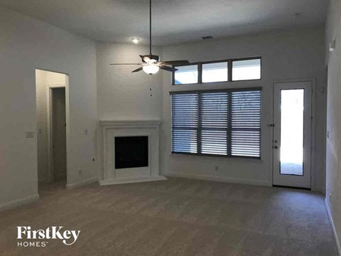 A spacious room with a fireplace and a ceiling fan.