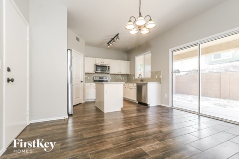A modern kitchen with wooden floors and a white cabinetry.