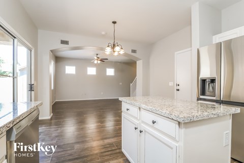 A kitchen with a marble countertop and a FirstKey Homes logo.