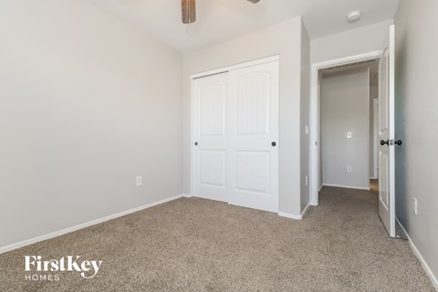 A room with a carpeted floor and a white door.
