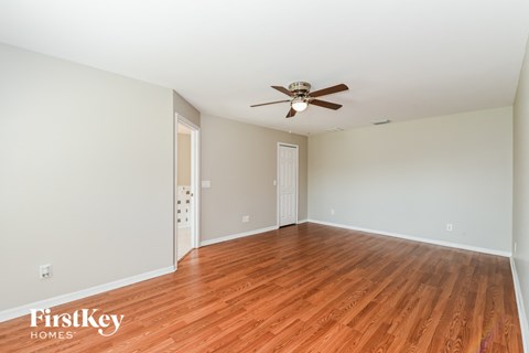 a living room with wood floors and a ceiling fan