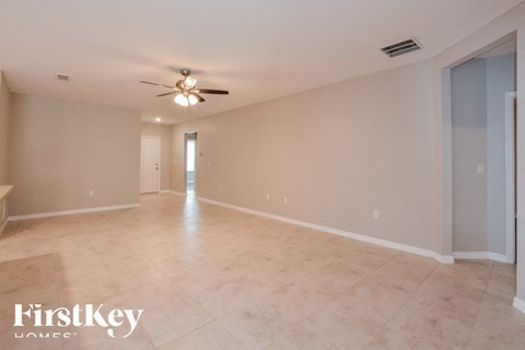 A spacious room with a ceiling fan and light fixture.