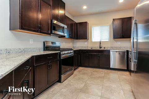 A kitchen with brown cabinets and a stainless steel refrigerator.