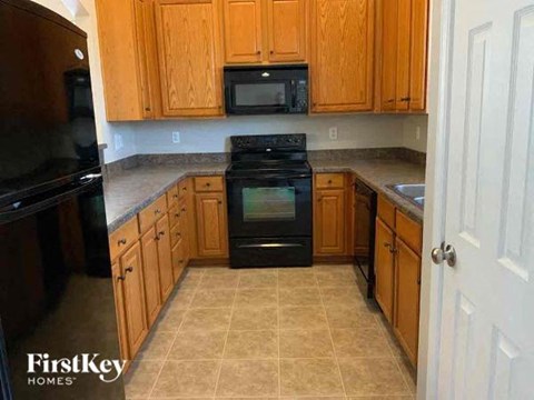A kitchen with wooden cabinets and a black oven.