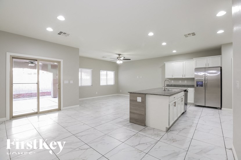 A spacious kitchen with a refrigerator, sink, and cabinets.