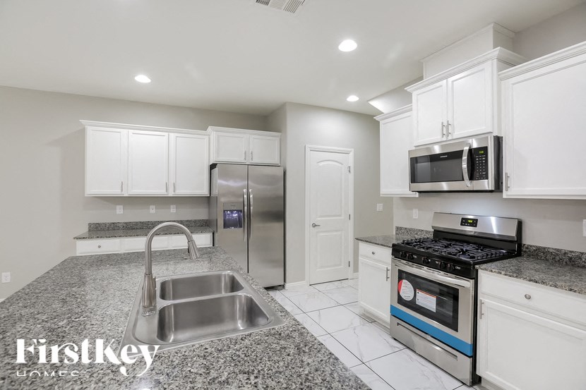 A kitchen with granite countertops and stainless steel appliances.