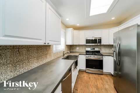 A kitchen with a stove top oven and a refrigerator.