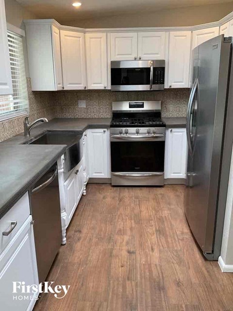 A kitchen with a refrigerator, stove, and oven.