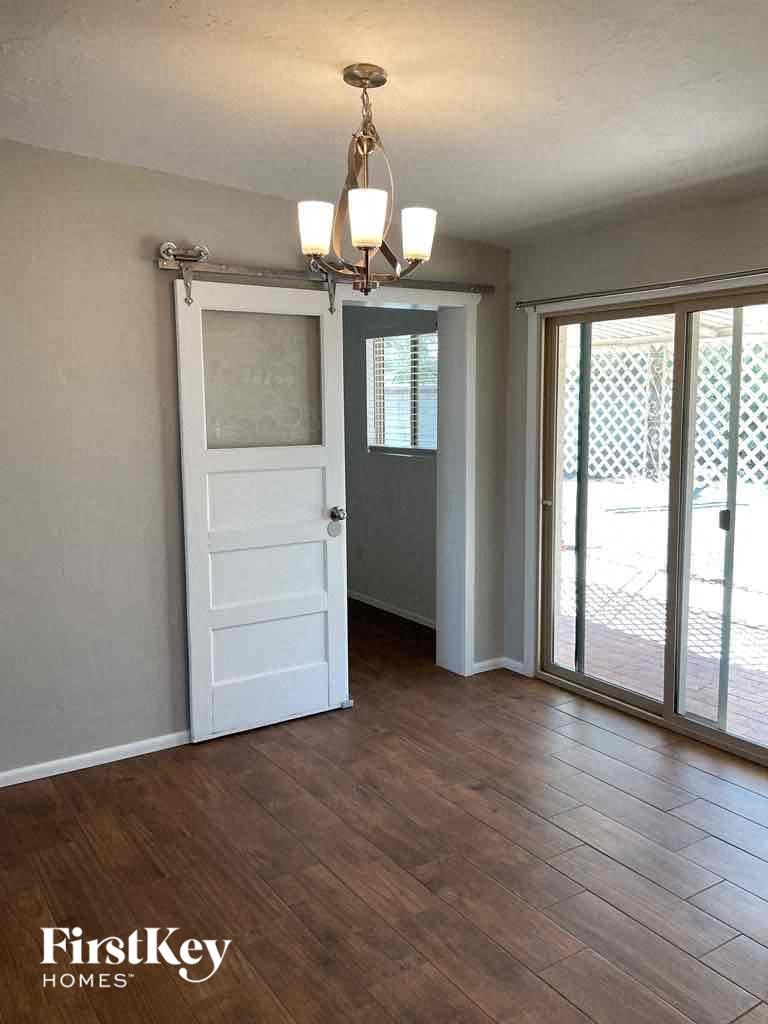 A room with a wooden floor and a chandelier.