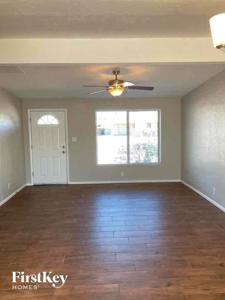 A room with a wooden floor and a ceiling fan.