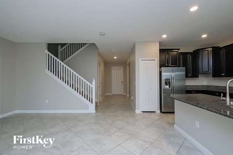 a kitchen with a staircase and a refrigerator and a sink