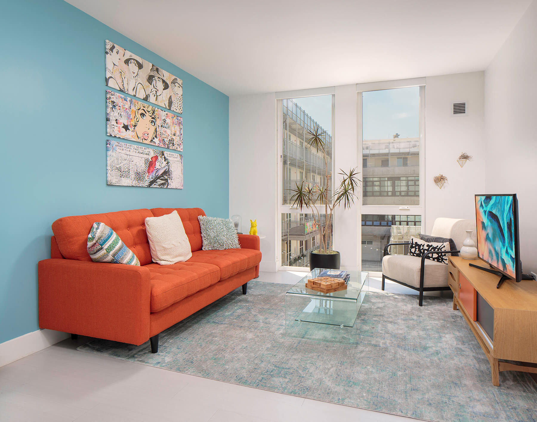 a living room with a orange couch and a window