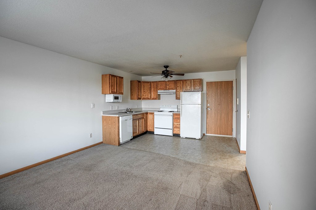A kitchen with white appliances and wooden cabinets.