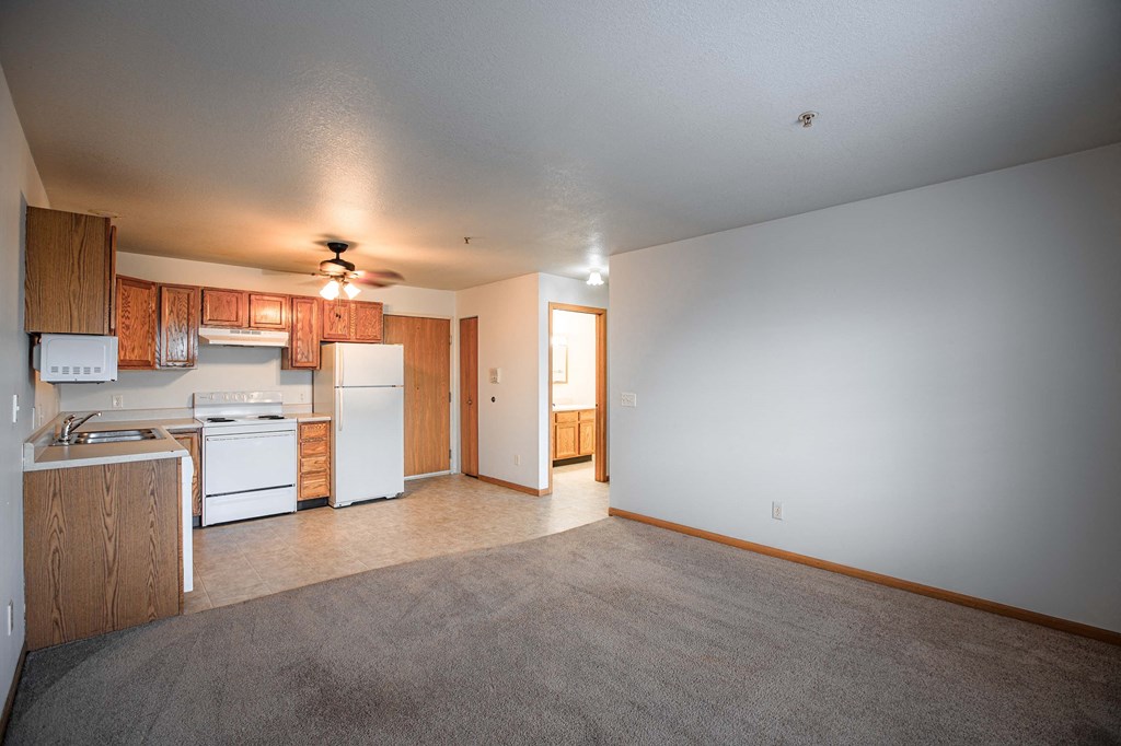 A kitchen with white appliances and wooden cabinets.