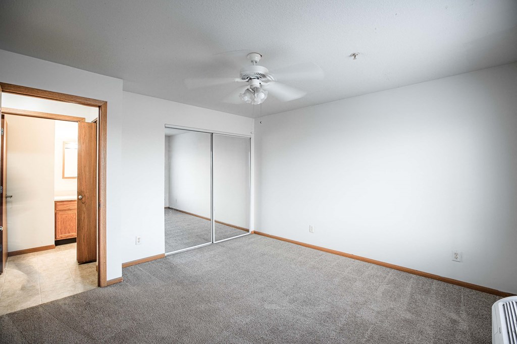 A room with a ceiling fan and a carpeted floor.
