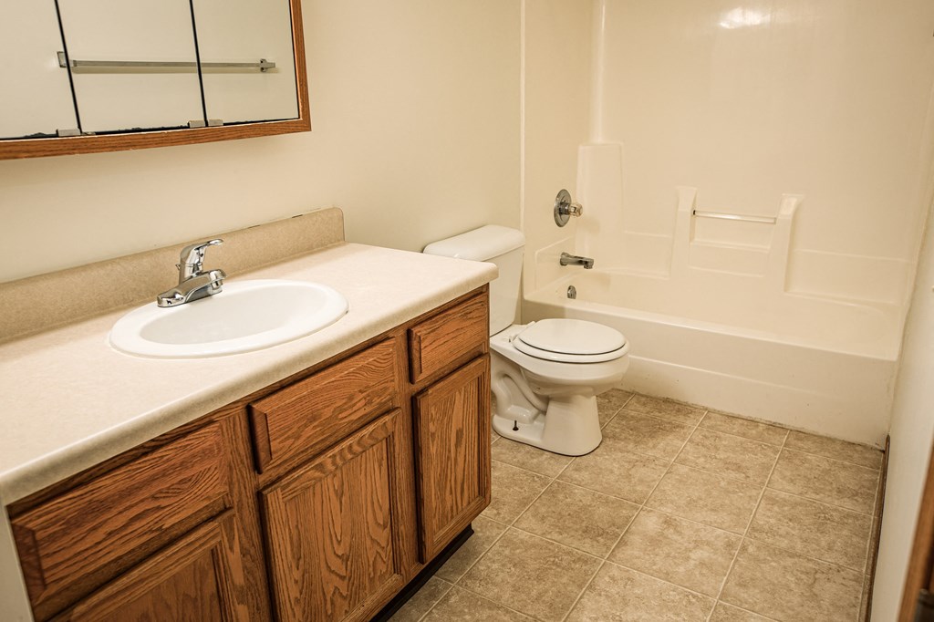 A bathroom with a sink, toilet and bathtub.