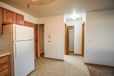 A kitchen with a white refrigerator and wooden cabinets.