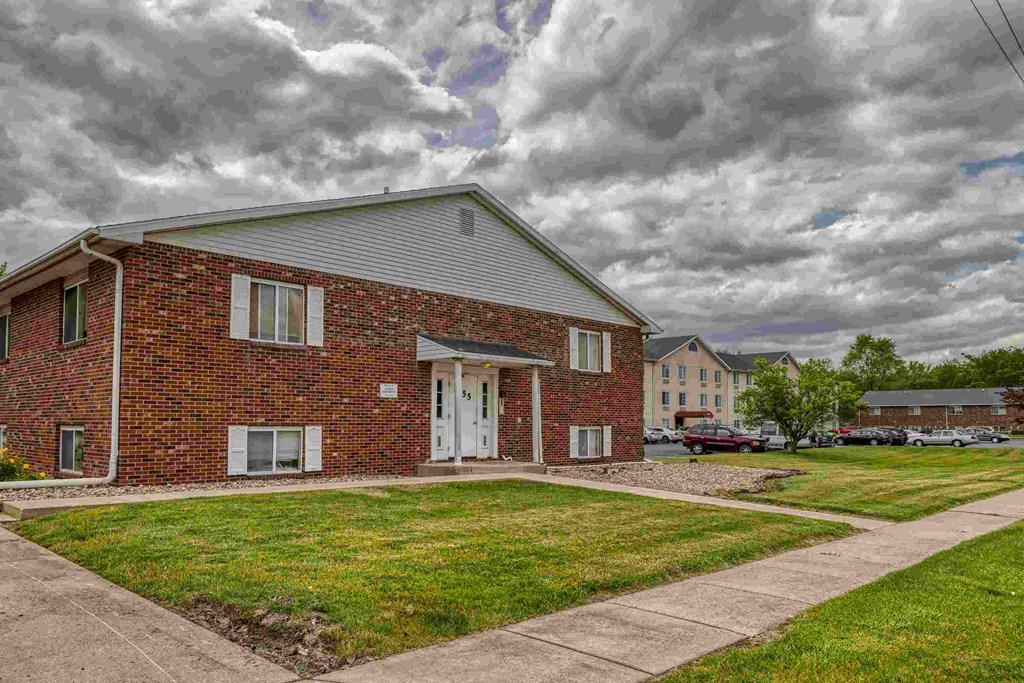 A red brick house with a white door and windows.