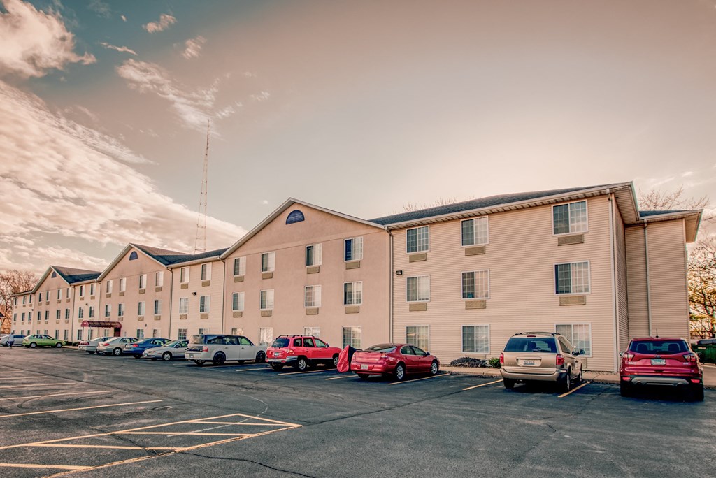 A parking lot with cars and a building in the background.
