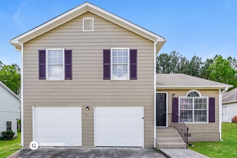 a tan house with a white garage door