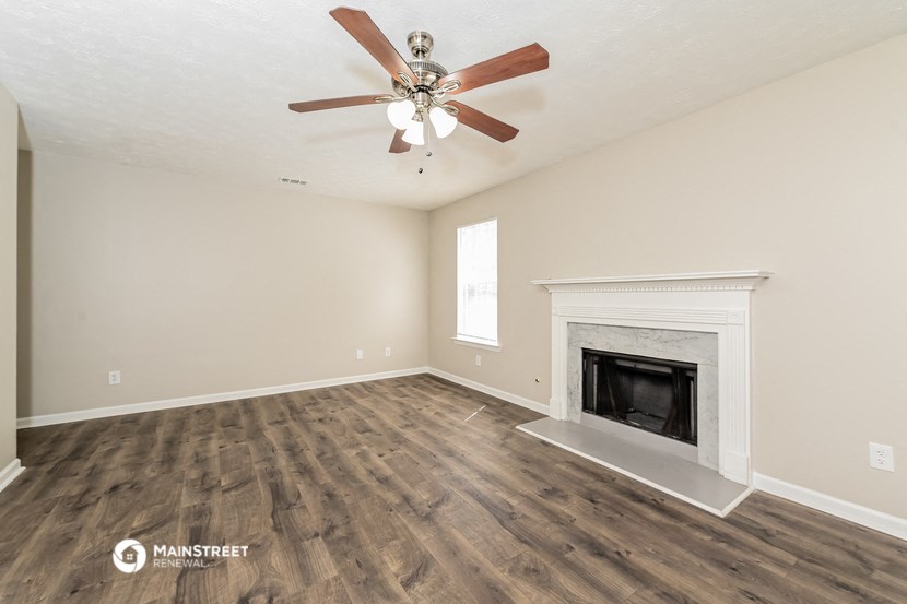 the living room with fireplace and ceiling fan