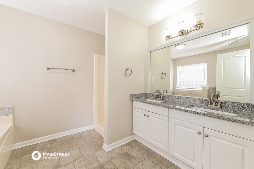a bathroom with white cabinets and a sink and a mirror