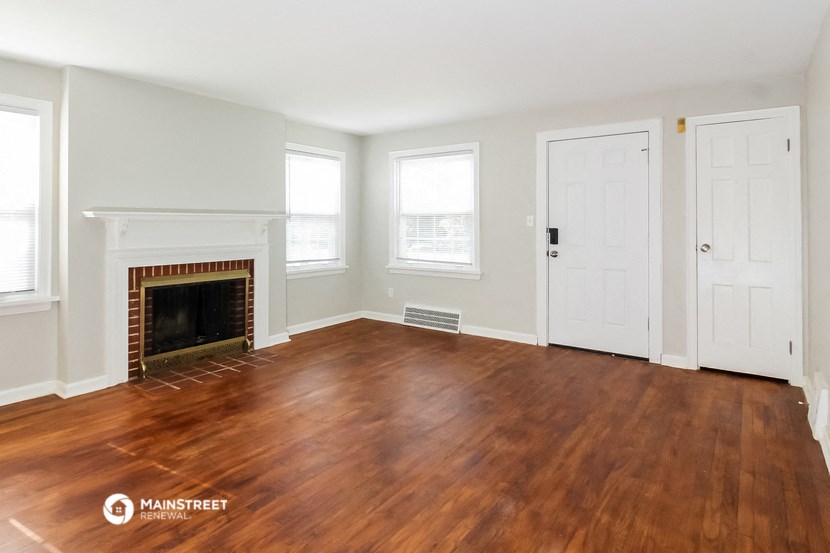 the living room with wood flooring and a fireplace