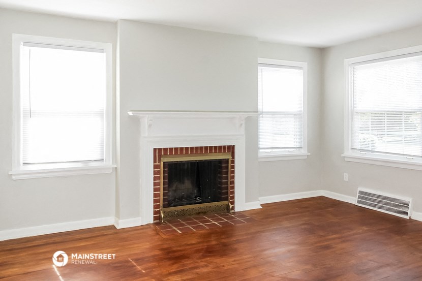 a living room with a fireplace and a wooden floor