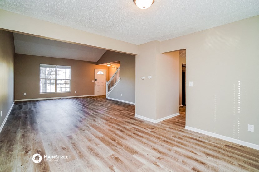 the living room and dining room of an empty house
