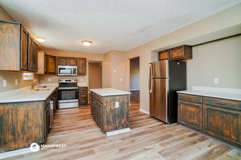 a kitchen with wooden cabinets and a refrigerator