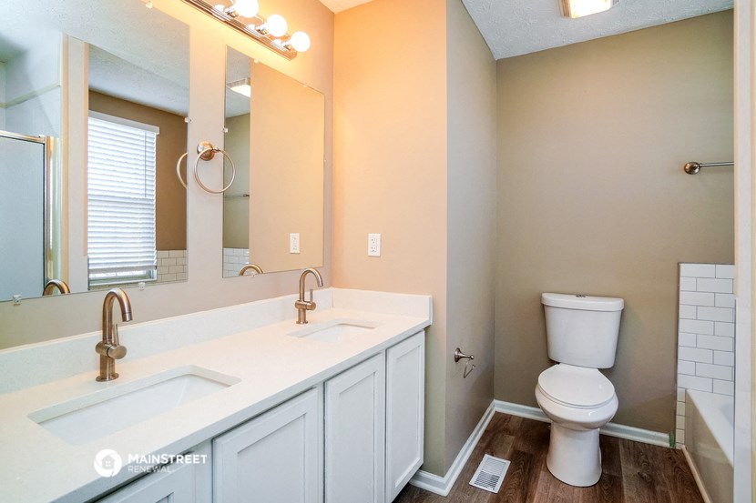 a bathroom with a large mirror and a sink and a toilet