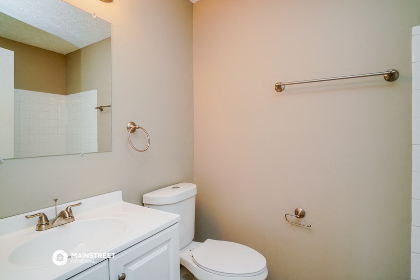 a bathroom with a sink toilet and a mirror