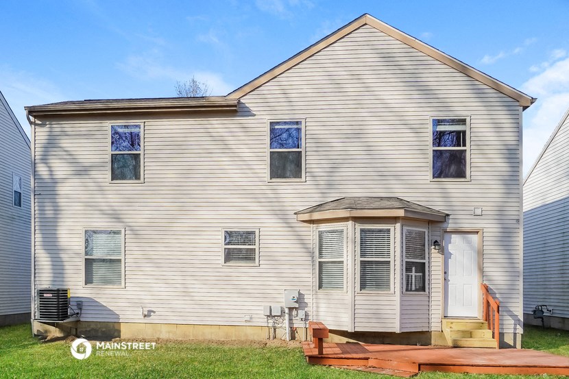a white house with white siding and a wooden fence