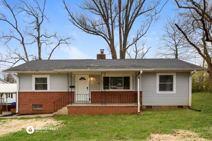 the front of a white house with a brick porch